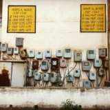 abandoned electricity meter boxes on a wall of old building