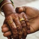 a hand holding a wedding ring and another hand holding a hand
